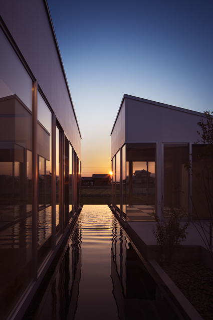 水盤の夕日とリビングと離れの徳島鳴門の平屋の住宅外観設計
