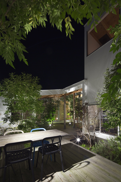 コートハウス中庭のアウトドアリビングダイニングの夜景住宅設計